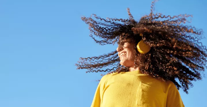 Момиче с жълт пуловер и слушалки