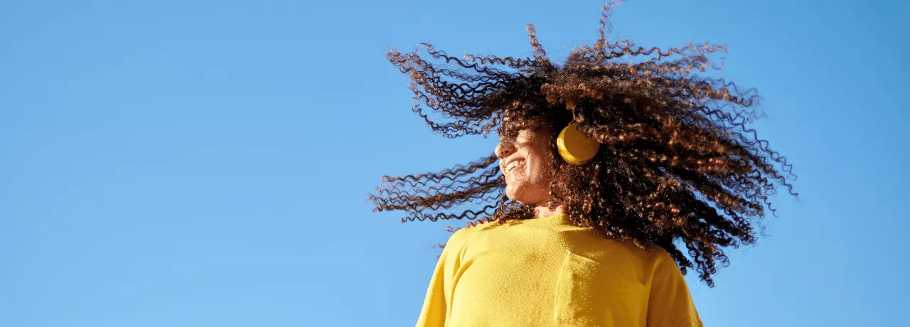 Момиче с жълт пуловер и слушалки