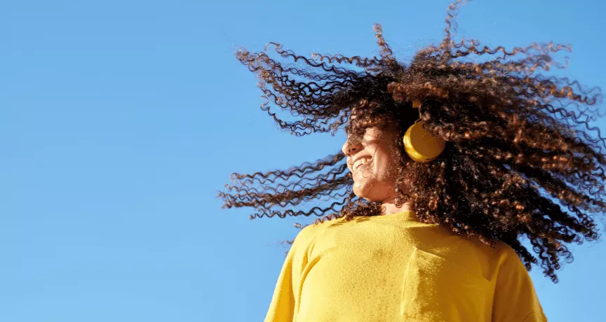 Момиче с жълт пуловер и слушалки