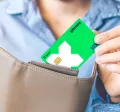 Жена слага карта Pluxee в портмонето си