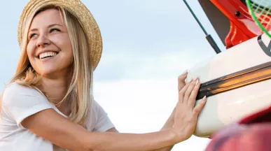 Жена прибира куфар в автомобил