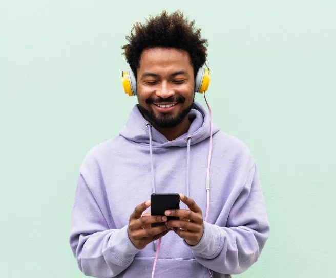 Човек със слушалки и телефон